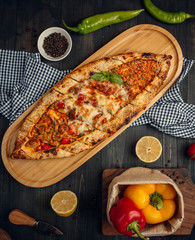 Mix turkish flatbread pide with minced meat, cheese, roasted meatcubes and vegetable