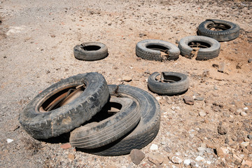 old car tires dumped in desert landscape -