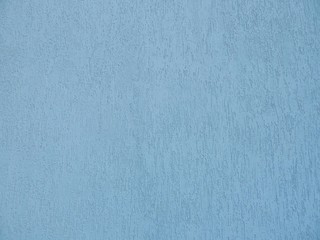 Beautiful light blue background. Blue wall of a building close-up. Decorative plaster.