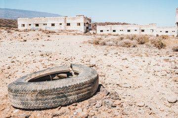 old car tire dumped in desert landscape -