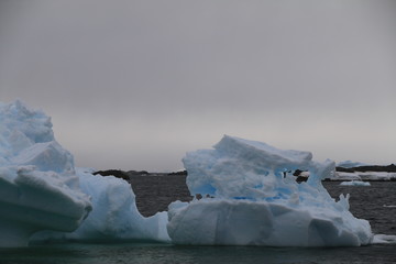 potężne bryły lodu dryfujące na wodach koła podbiegunowego u wybrzeży antarktydy