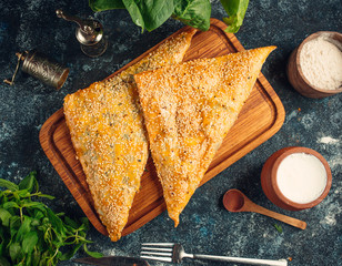 Triangled-shape bourekas baked pie with sesame seeds
