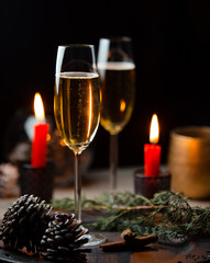 Two glasses of champagne for christmas table with red candles