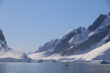 spokojne zimne wody pomiędzy ośnieżonymi skałami u wybrzeży antarktydy w piękny słoneczny...