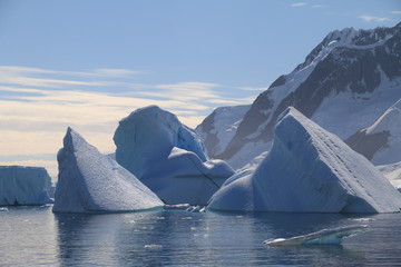 piękne duże bryły lodu i śniegu dryfujące przy wybrzeżu antarktydy w słoneczny dzień - obrazy, fototapety, plakaty