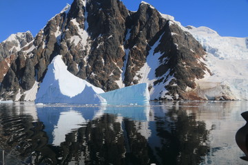 spokojne zimne wody pomiędzy ośnieżonymi skałami u wybrzeży antarktydy w piękny słoneczny dzień - obrazy, fototapety, plakaty