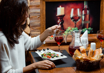 Woman eating greek salad with fruit juice and bread