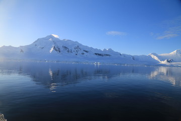 skaliste i ośnieżone wybrzeże antarktydy w słoneczny dzień © KOLA  STUDIO