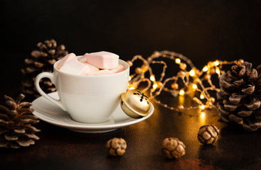 Warm cocoa drink with marshmallows. Christmas and New Year drink. Christmas Eve mood. Christmas lights and decorations. Winter holidays concept. Dark background. Copyspace