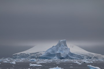 malownicze kry i góry lodowe na spokojnym morzu w pochmurny dzień - obrazy, fototapety, plakaty