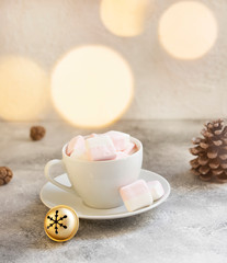 White cup with a warm cocoa drink with marshmallows on a light background. Winter festive Christmas drink. Christmas mood. Selective focus