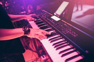 Musicians are playing keyboards in concert.