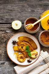 Roasted, baked pumpkin with apples, slices and mint. Healthy food concept with copy space.