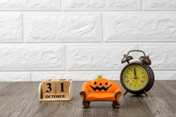 orange couch decor figurines  miniature and wooden calender that show 31 october on white wall...