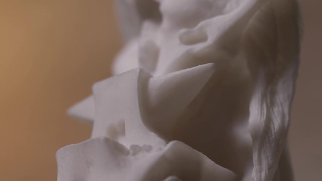 Closeup on a white marble statue of the Greek god Hephaestus. Panning from down to high.