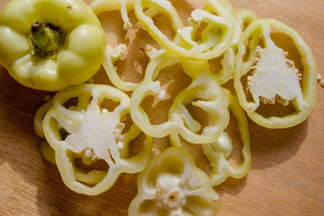 Sliced green peppers on a wooden background. yellow pepper on the table. Flat lay, top view, copy space