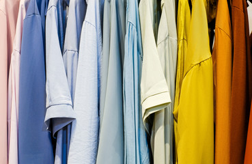 Fashionable clothes on a hanger. Close - up of clothes in the store rainbow color. Selection of clothing in the store. Colorful clothes on a hanger.