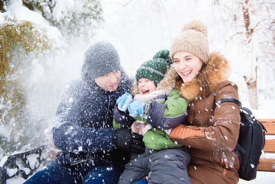 happy family having fun and playing with snow in forest