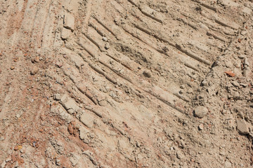 Crawler traces on yellow mud ground surface closeup background pattern