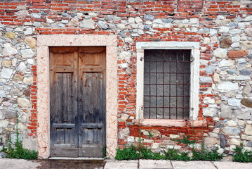 Altes Backsteinmauerwerk mit Tür und Fenster
