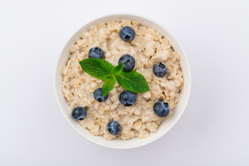 Oatmeal porridge with blueberries and mint on white background NOT isolated