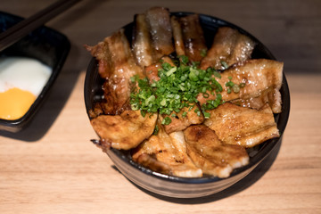 Butadon in bowl of rice topped with sliced pork and sweet sauce