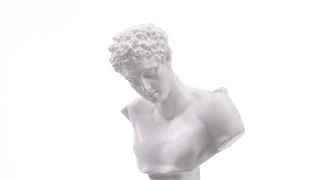 Old roman white marble statue rotating against a white background. Closeup shot