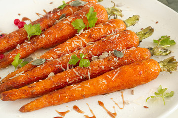 Close up Baked organic carrots with honey, parsley, cheese and flax, pumpkin, sunflower seed. Organic vegan food.