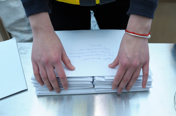 At the post office, sorting room: female postal worker standing at the work table and sorting...