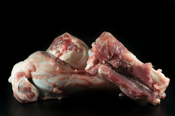 Two raw knuckle or joint bones on black