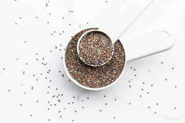 Chia seeds on white scoop on white background