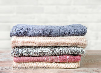  A stack of knitted scarves on a wooden table