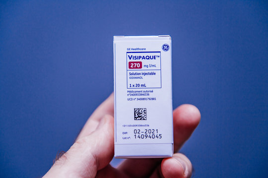 PARIS, FRANCE - OCT 2, 2018: Visipaque - Iodixanol package the contrast agent for the medical intervention under CT scanner on doctors table - iodine-non-ionic radiocontrast agent - blue background
