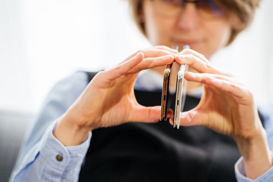 PARIS, FRANCE - OCT 2, 2018: Tech business woman compare thickness of the new Apple iPhone Xs siw Xs Max smartphone telephone from Apple Computers