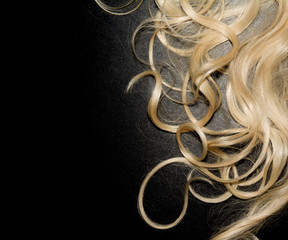 white curly hair on a black background. blonde wig. top view background