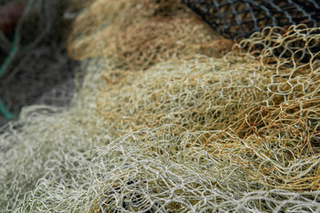 A mesh of white and orange fishing net in the summer sun.