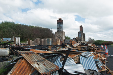 Fototapeta na wymiar Fire damaged home with two chimneys,
