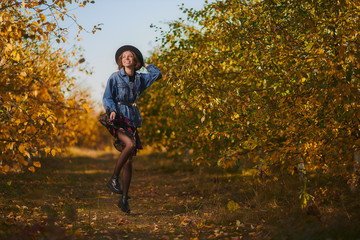 A young girl walks through the autumn forest with yellow leaves