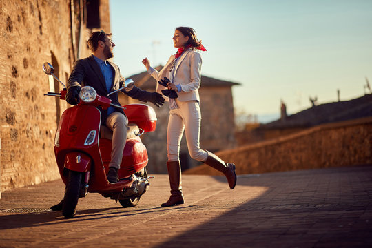 Fototapeta Business people on scooter..scooter in the city. Happy couple riding scooter..