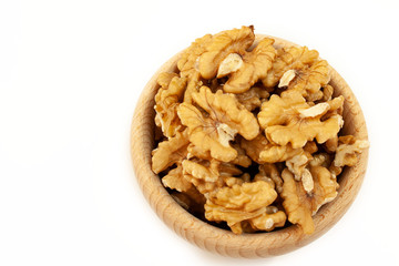 Wooden bowl filled with walnuts on a white background