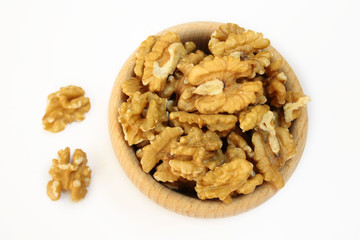 Wooden bowl filled with walnuts on a white background