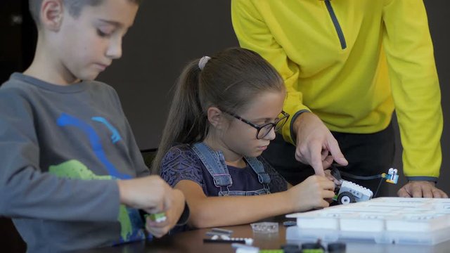 Kids creating robots with teacher. Early development, innovation, modern technology concept