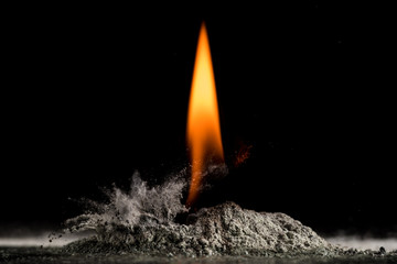 burning sand and a splash of water on a black background, the fifth element