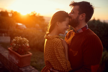 romantic man and woman kissing at sunset.