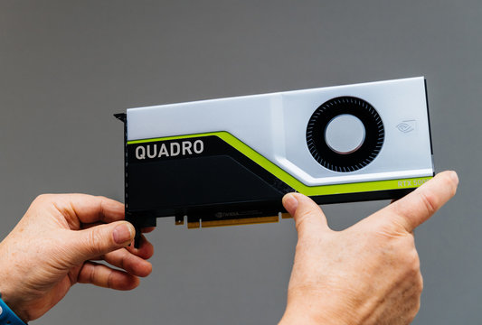 Paris, France - Mar 28 2019: Senior man showing latest Nvidia Quadro RTX 5000 workstation GPU with texture mapping units, render output units, streaming multiprocessors, tensor cores gray background