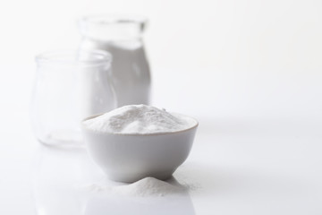Obraz na płótnie Canvas Jar with artificial sweetener aspartame E951 and a bowl on a white glossy background