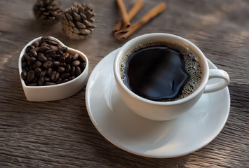 cup of coffee with beans on wooden table