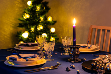 Christmas table setting with christmas tree in background