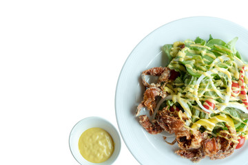Soft shell crab salad with salad dressing on isolated whiet background. Top view.