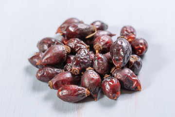 pile of dry rose hips on a wooden table